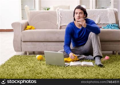The young good looking man knitting at home. Young good looking man knitting at home