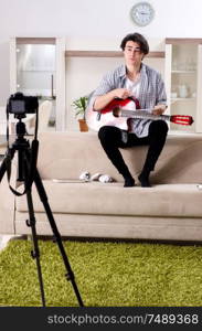 The young guitar player recording video for his blog . Young guitar player recording video for his blog