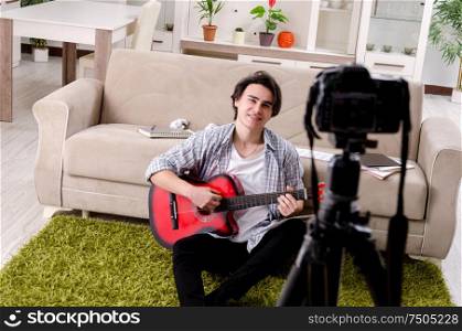 The young guitar player recording video for his blog. Young guitar player recording video for his blog