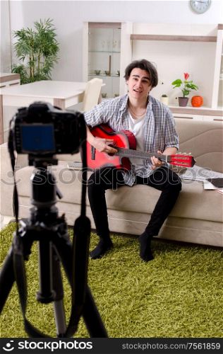 The young guitar player recording video for his blog. Young guitar player recording video for his blog