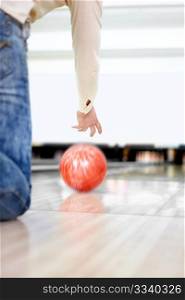 The young guy throws a sphere for bowling
