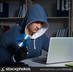 The young hacker hacking into computer at night. Young hacker hacking into computer at night