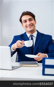 The young handsome businessman employee working in office at desk. Young handsome businessman employee working in office at desk