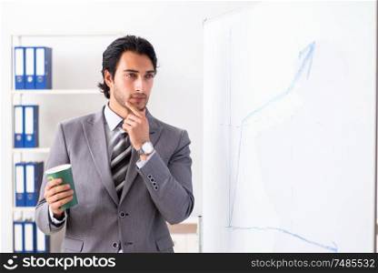 The young handsome businessman in front of whiteboard. Young handsome businessman in front of whiteboard