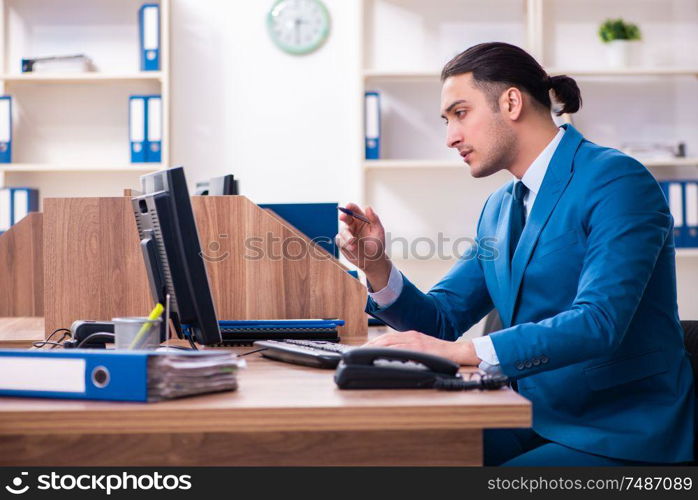 The young handsome businessman sitting in the office. Young handsome businessman sitting in the office