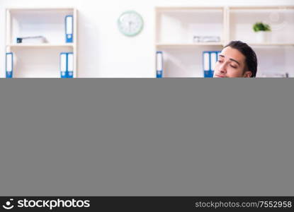 The young handsome businessman sitting in the office. Young handsome businessman sitting in the office