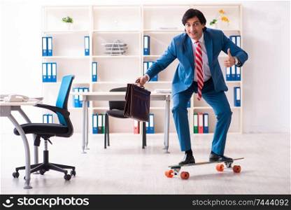 The young handsome businessman with longboard in the office . Young handsome businessman with longboard in the office 