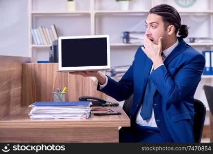 The young handsome businessman working in the office . Young handsome businessman working in the office 