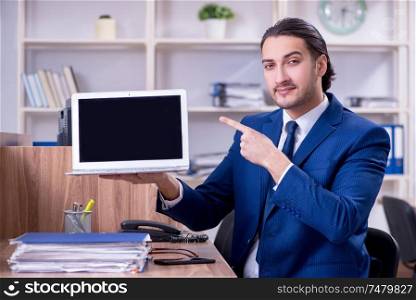 The young handsome businessman working in the office . Young handsome businessman working in the office