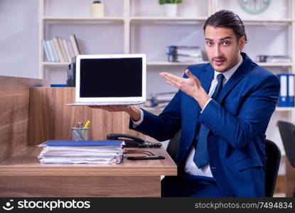 The young handsome businessman working in the office. Young handsome businessman working in the office