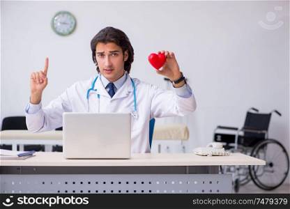 The young handsome doctor cardiologist working in the clinic . Young handsome doctor cardiologist working in the clinic