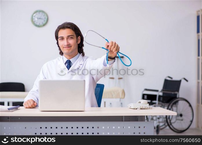 The young handsome doctor cardiologist working in the clinic. Young handsome doctor cardiologist working in the clinic