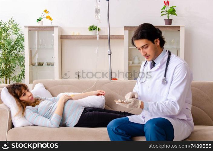 The young handsome doctor visiting pregnant woman at home. Young handsome doctor visiting pregnant woman at home