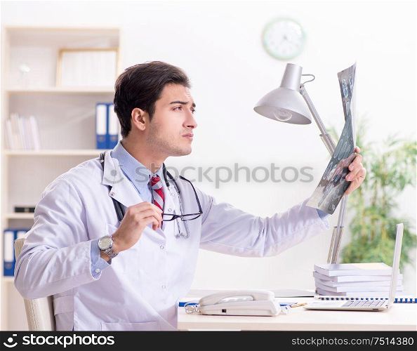The young handsome doctor working in hospital room. Young handsome doctor working in hospital room