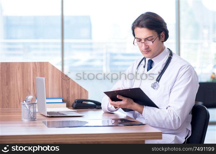 The young handsome doctor working in the clinic. Young handsome doctor working in the clinic