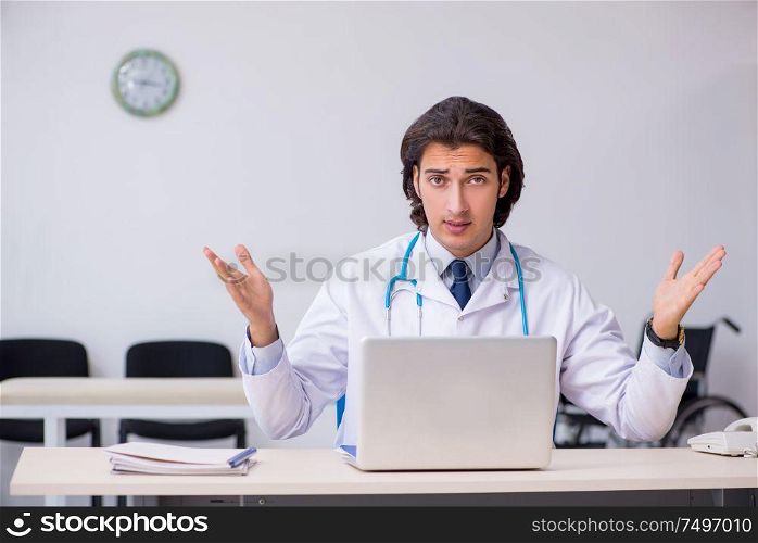 The young handsome doctor working in the clinic. Young handsome doctor working in the clinic