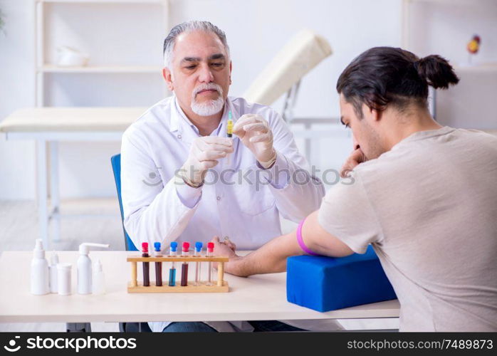 The young handsome man during blood test sampling procedure. Young handsome man during blood test sampling procedure