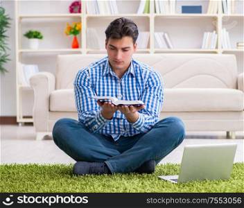 The young handsome man sitting on floor at home. Young handsome man sitting on floor at home