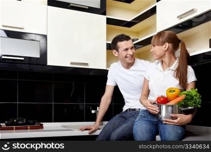 The young happy couple sits at kitchen