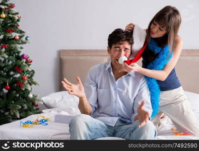 The young happy family celebrating christmas in bed. Young happy family celebrating christmas in bed