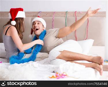 The young happy family celebrating christmas in bed. Young happy family celebrating christmas in bed