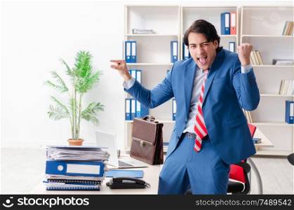 The young happy male employee in the office . Young happy male employee in the office