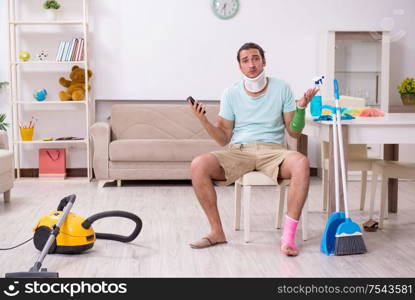 The young injured man cleaning the house. Young injured man cleaning the house