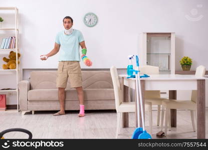 The young injured man cleaning the house. Young injured man cleaning the house