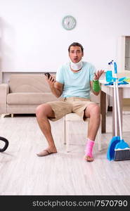 The young injured man cleaning the house. Young injured man cleaning the house