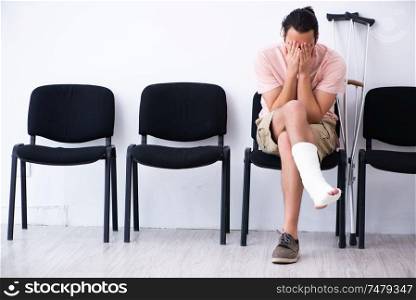 The young injured man waiting for his turn in hospital hall. Young injured man waiting for his turn in hospital hall