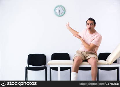 The young injured man waiting for his turn in hospital hall. Young injured man waiting for his turn in hospital hall