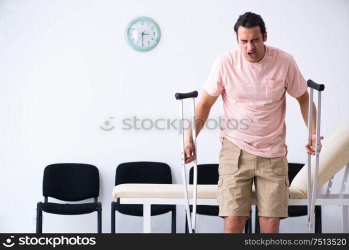 The young injured man waiting for his turn in hospital hall. Young injured man waiting for his turn in hospital hall