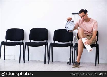 The young injured man waiting for his turn in hospital hall. Young injured man waiting for his turn in hospital hall
