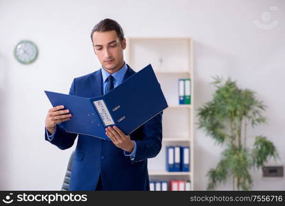 The young male accountant working in the office. Young male accountant working in the office