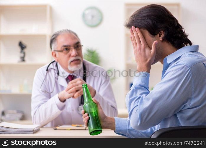 The young male alcoholic visiting old doctor  . Young male alcoholic visiting old doctor  