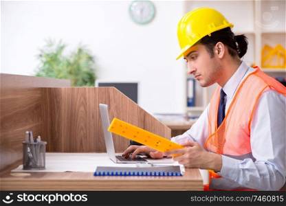 The young male architect working in the office . Young male architect working in the office 