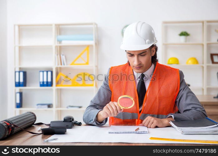 The young male architect working in the office . Young male architect working in the office