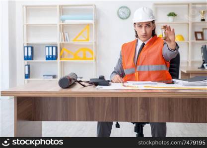 The young male architect working in the office . Young male architect working in the office