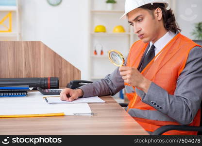 The young male architect working in the office. Young male architect working in the office