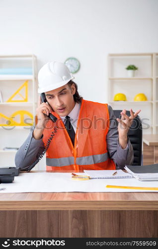 The young male architect working in the office. Young male architect working in the office