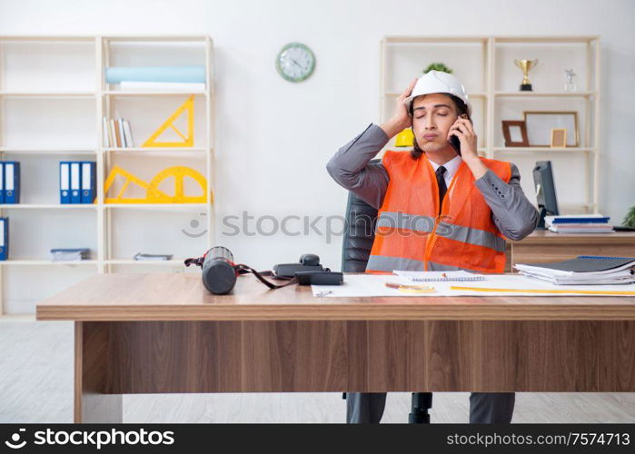 The young male architect working in the office. Young male architect working in the office