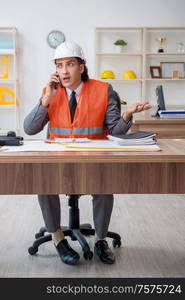 The young male architect working in the office. Young male architect working in the office