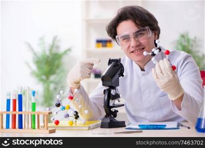 The young male biochemist working in the lab . Young male biochemist working in the lab 
