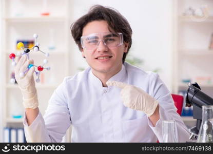 The young male biochemist working in the lab . Young male biochemist working in the lab 