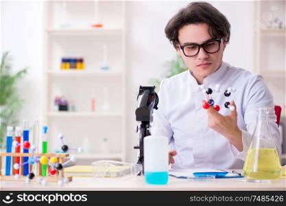 The young male biochemist working in the lab . Young male biochemist working in the lab