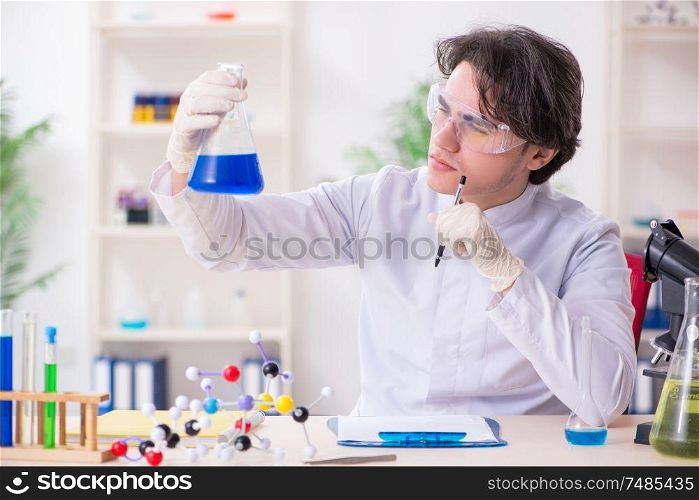 The young male biochemist working in the lab. Young male biochemist working in the lab