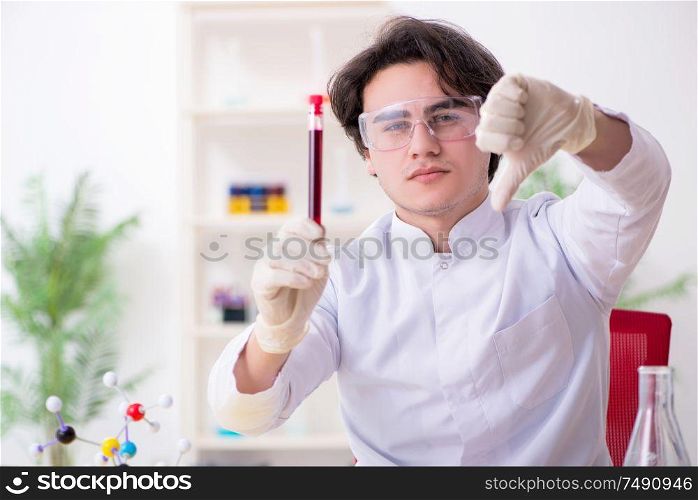 The young male biochemist working in the lab. Young male biochemist working in the lab