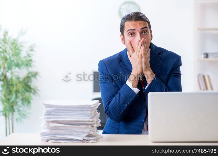 The young male businessman sitting in the office. Young male businessman sitting in the office