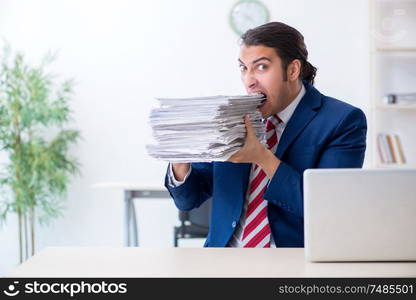 The young male businessman sitting in the office . Young male businessman sitting in the office