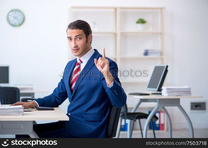 The young male businessman sitting in the office. Young male businessman sitting in the office